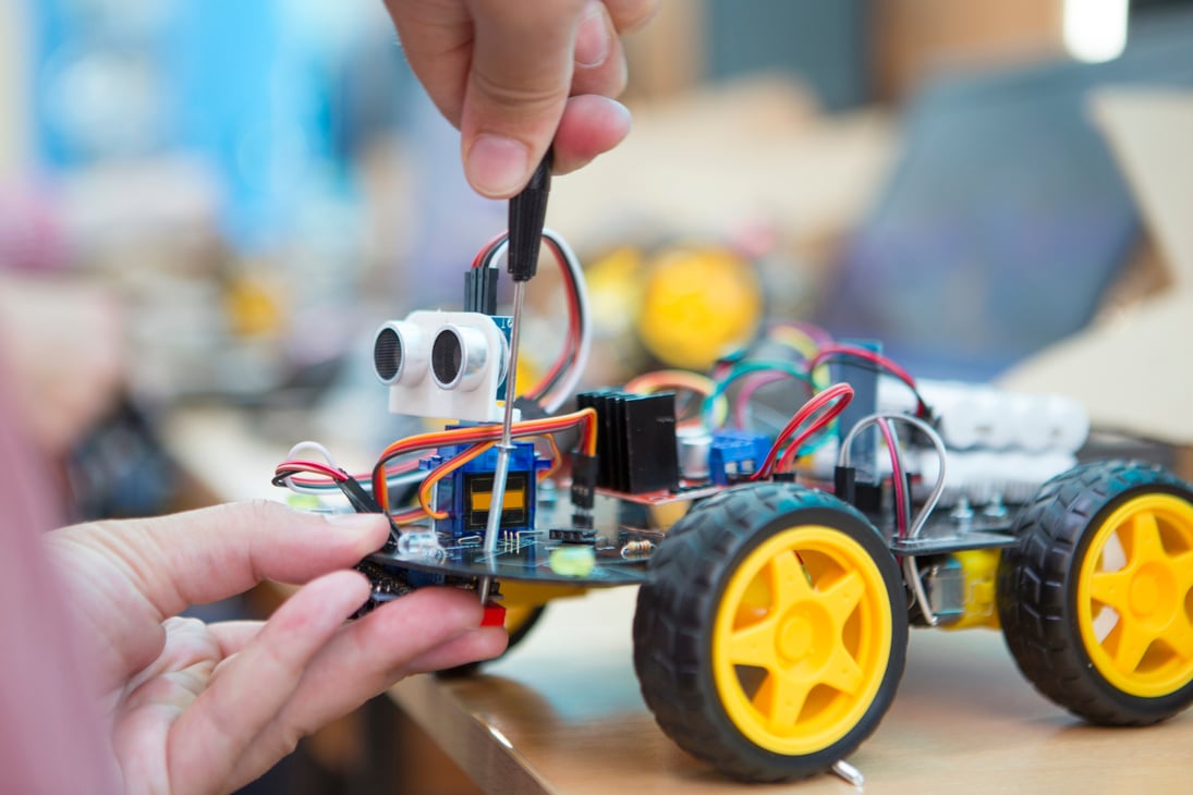 student doing robot with screwdriver in robotics coding class