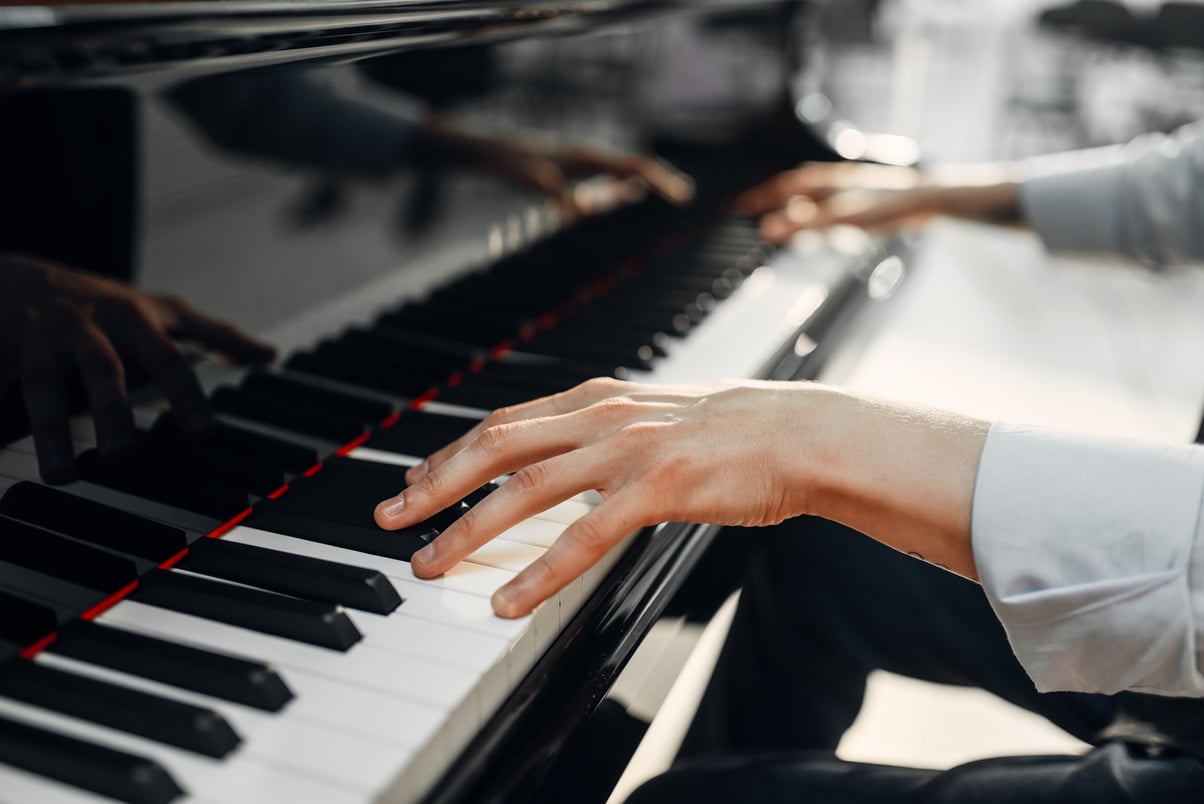 Male pianist hands on grand piano keyboard