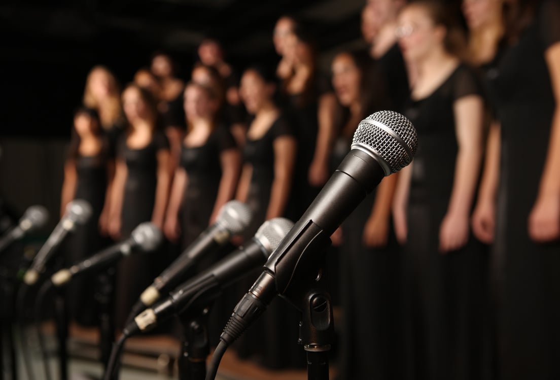 Shot of microphones with choir in the background