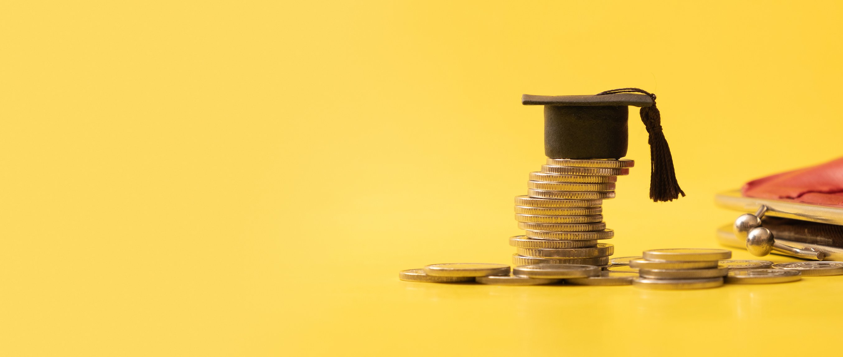 Banner with graduated cap with coins on yellow background. Savin